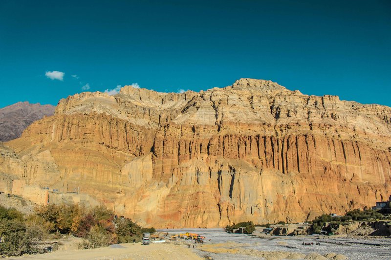 Himalayan Royal Enfield parked near Lo Manthang with rugged Mustang cliffs in the background