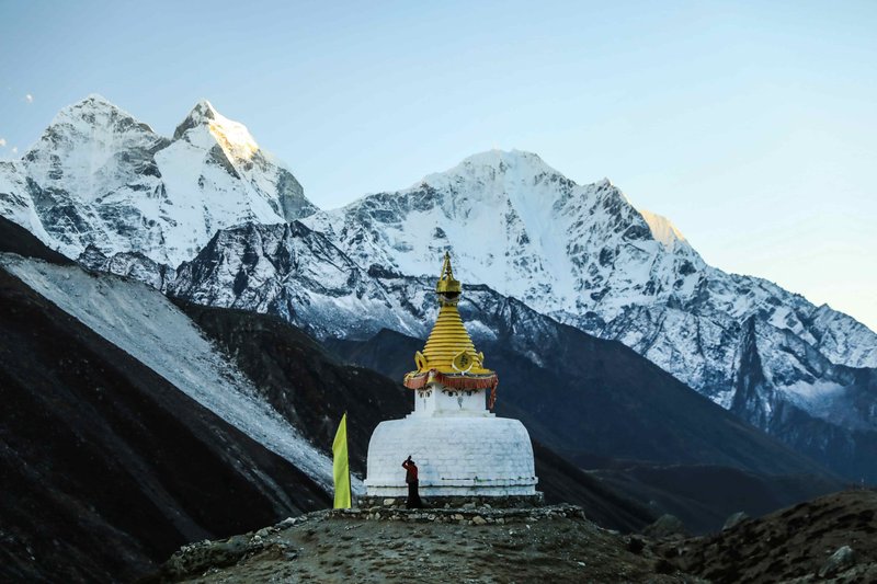 Golden-topped Buddhist stupa at Pikey Peak with stunning Himalayan mountain views in the background, Nepal trekking route.