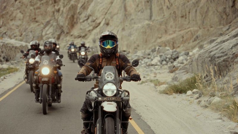 Group of motorbike riders exploring Upper Mustang on Himalayan Royal Enfield motorcycles through rugged mountain trails