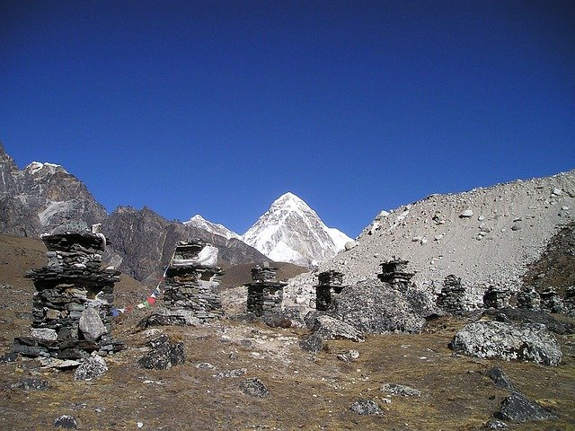 Traditional stone memorial chortens along the Pikey Peak trekking trail with panoramic views of Himalayan peaks in Nepal.