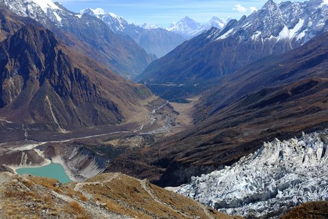 Steep mountain path along the Budhi Gandaki River valley on the Manaslu Circuit, flanked by terraced fields.